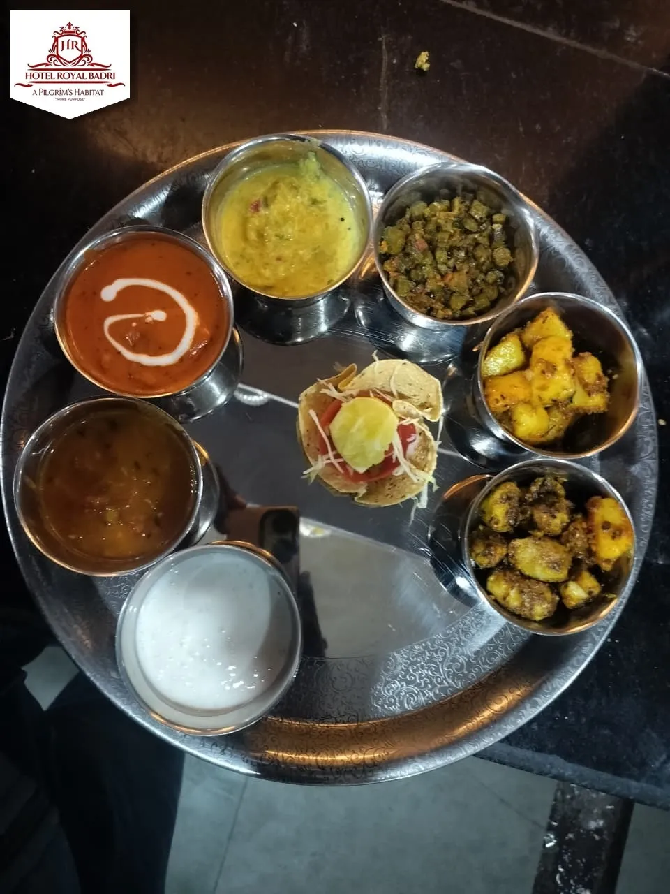 Traditional Pahadi thali with roti, sabzi and dal served on a steel tray
